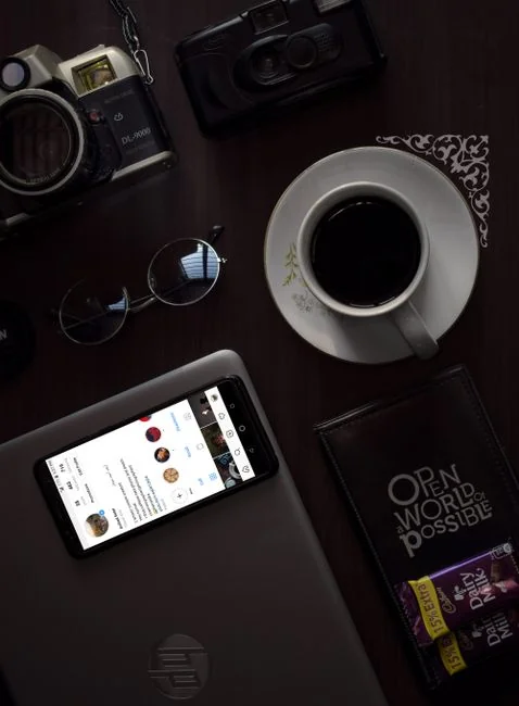 Person relaxing indoors with coffee and smartphone, texting in a cozy setting.